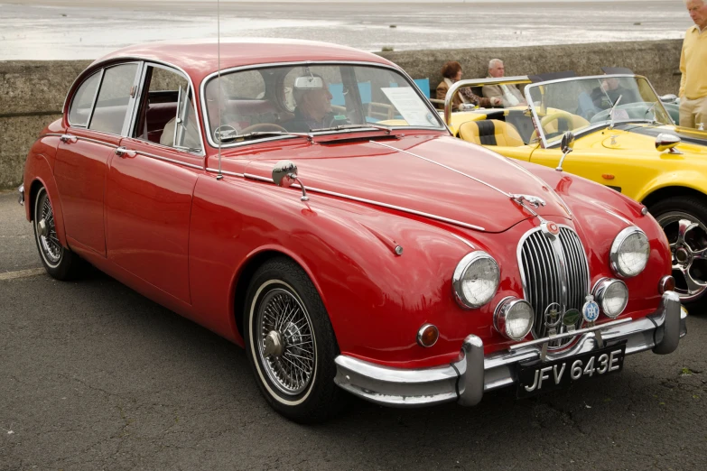 there are two vintage cars that are parked on the street