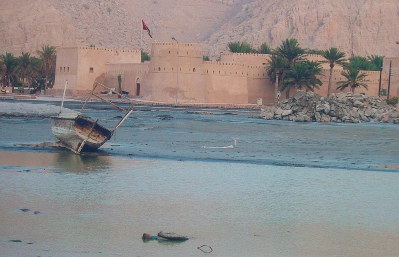 the boat is in the water next to the mountains