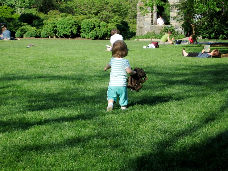 there is a young child running in the field holding a baseball glove
