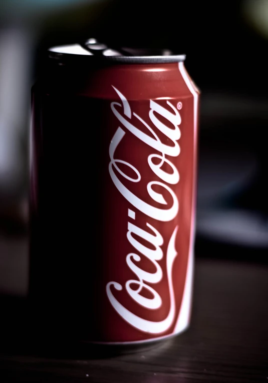 a coca - cola can is sitting on the table