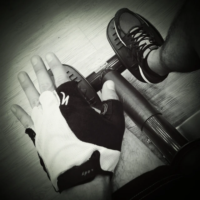 person's hand with black and white tennis glove holding a tennis racquet