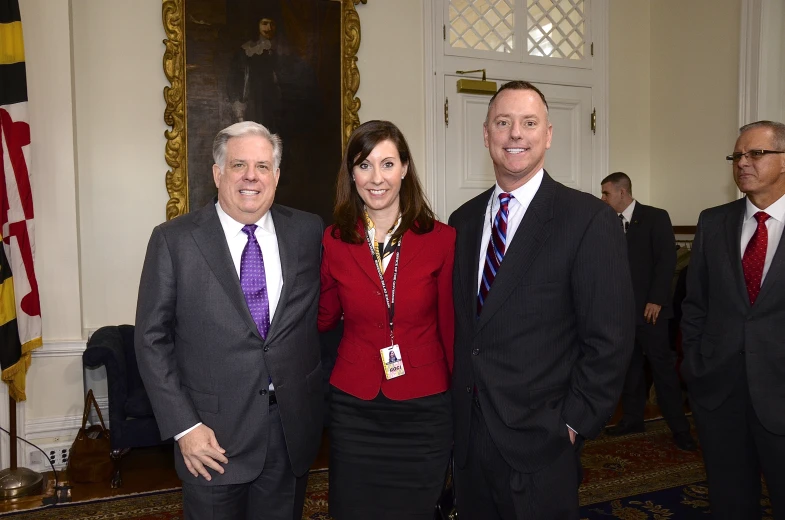 three people standing with one person in a suit and tie