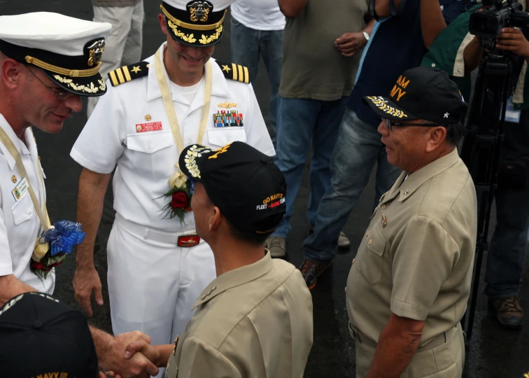 two men in uniforms are shaking hands with two other men