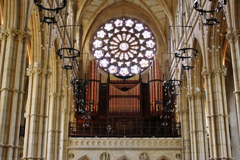 an intricate ceiling has a stained glass window behind it