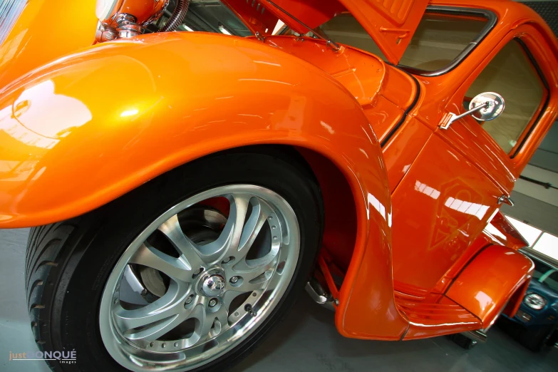 an orange vw bug is shown parked inside a garage