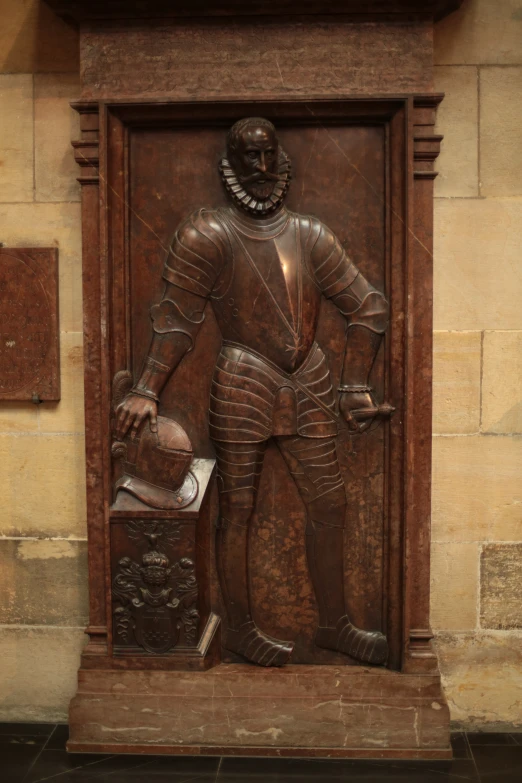 a bronze statue with a large iron body and a hat