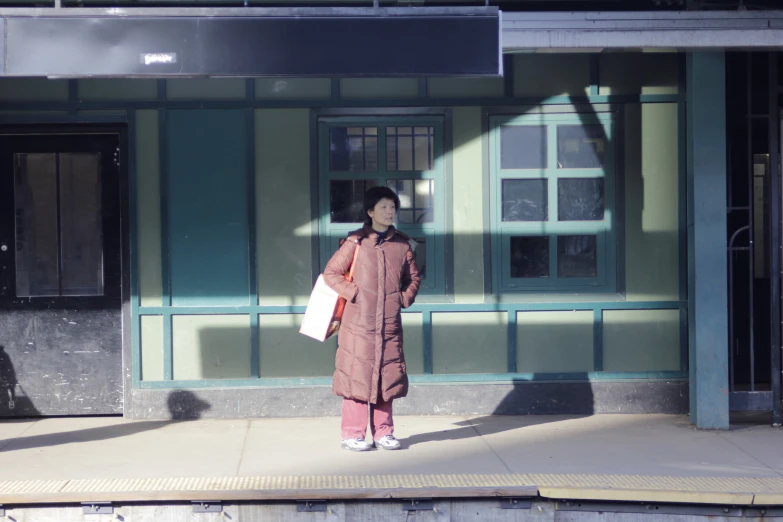 an oriental woman stands in front of a building