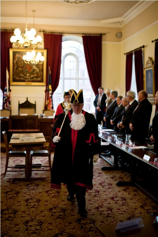 a group of people in suits, and a crown walking away