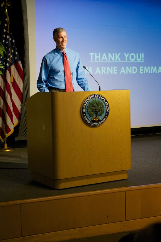 a man stands at the podium with a microphone