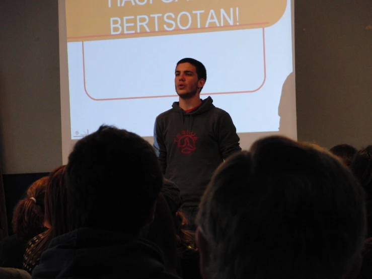 a man standing in front of a crowd at a conference