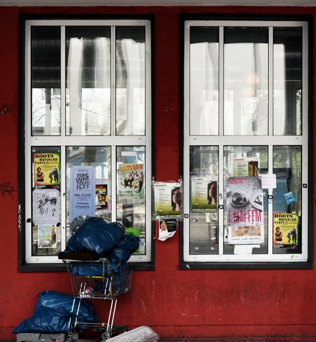 a red building with a store front covered in posters and signs