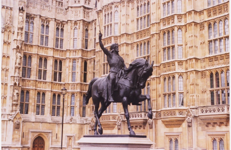 a statue of a man on top of a horse next to a building