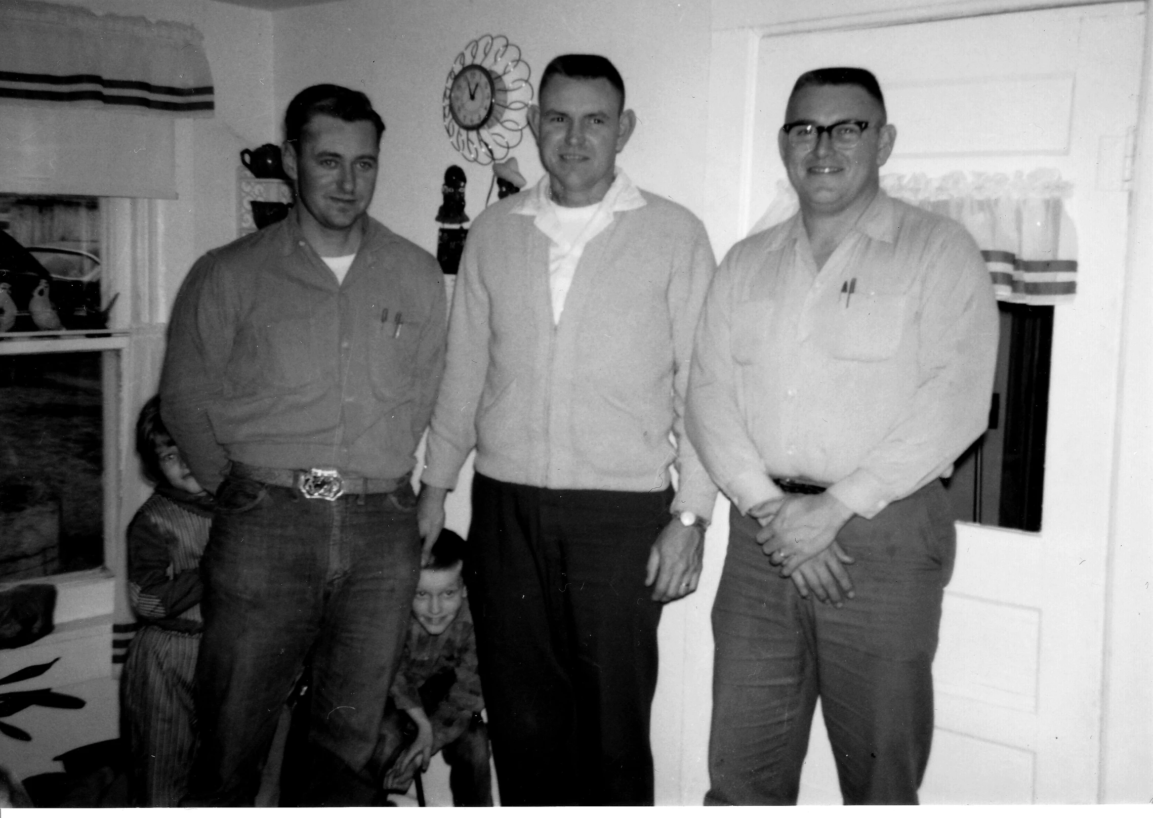 three men are standing in the middle of the room