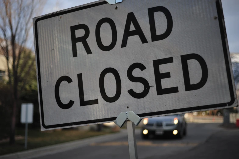 a road sign that has the words road closed written under it