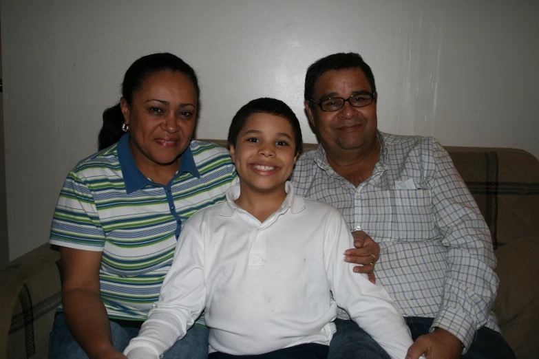 three people sitting next to each other on a couch