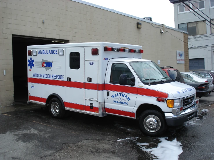 an ambulance parked in a parking lot in front of a brick building
