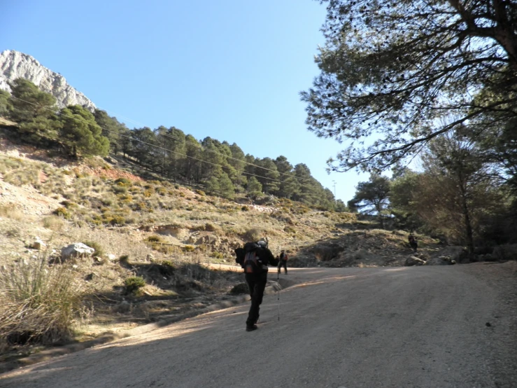a lone man walking on a hill road
