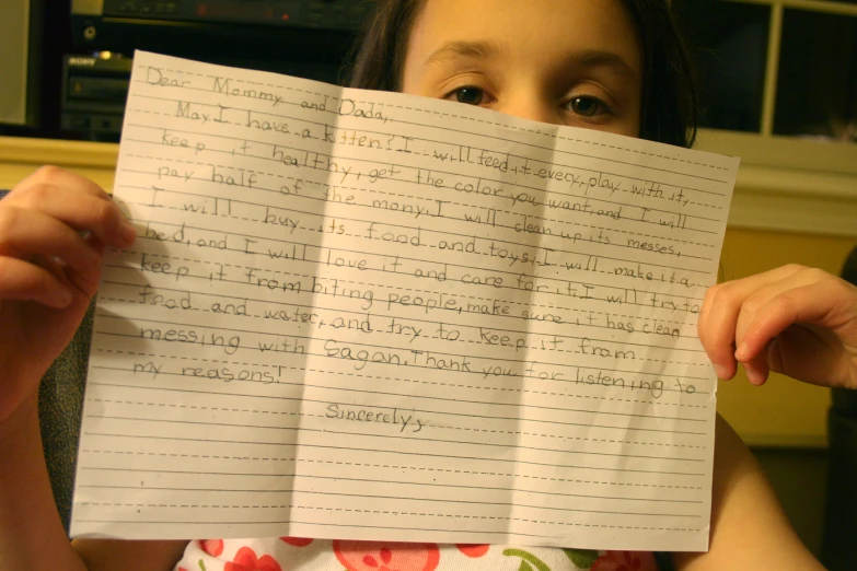 a girl holds several sheets of paper with writing on them