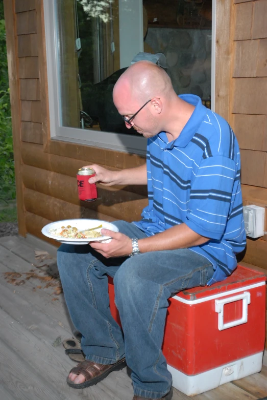 a man holding a can and a plate of food