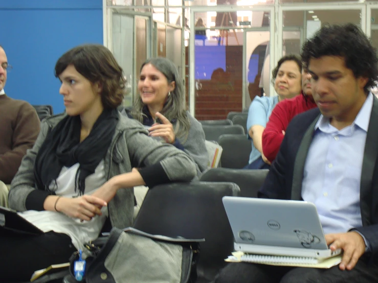 people sitting in a row while one person looks at his computer