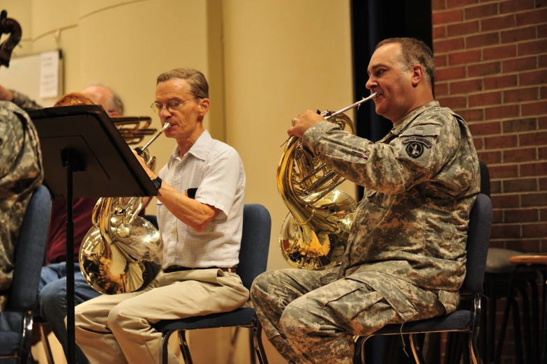 two soldiers sitting next to each other with instruments in their hands