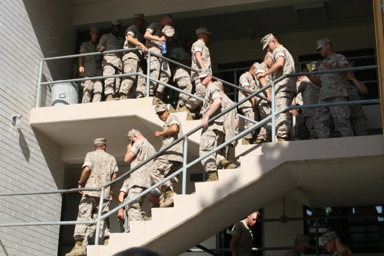 military men in uniform entering a building down stairs