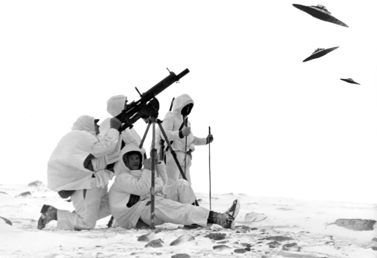 four men in white suits stand around in the snow