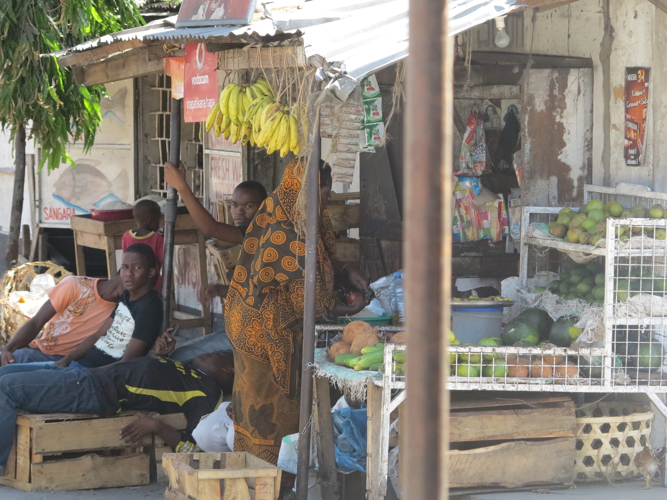 a group of people are standing and sitting outside of a store