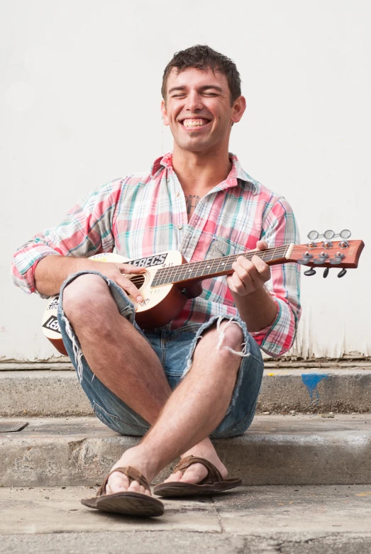 a smiling man with a guitar in his hand