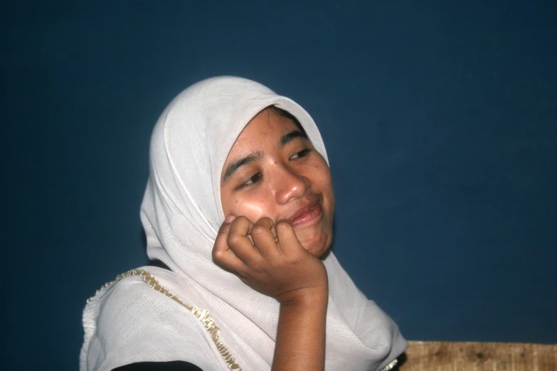 a smiling woman with a white head scarf