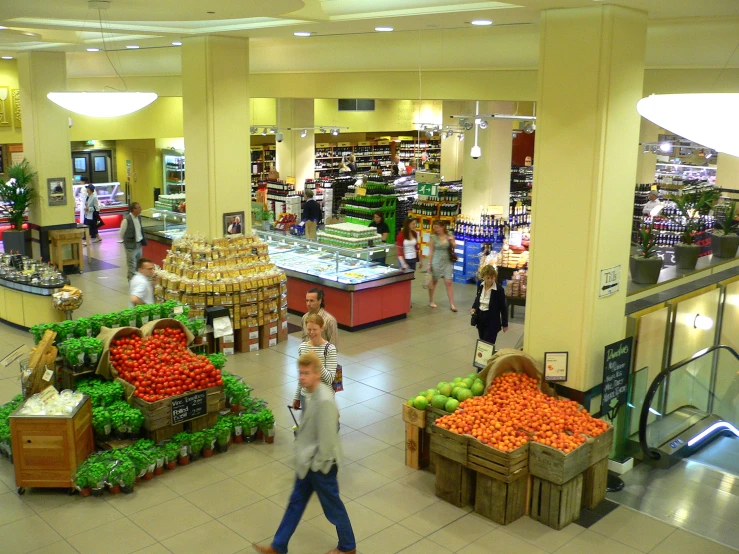 a very wide view of a grocery store that is crowded with people