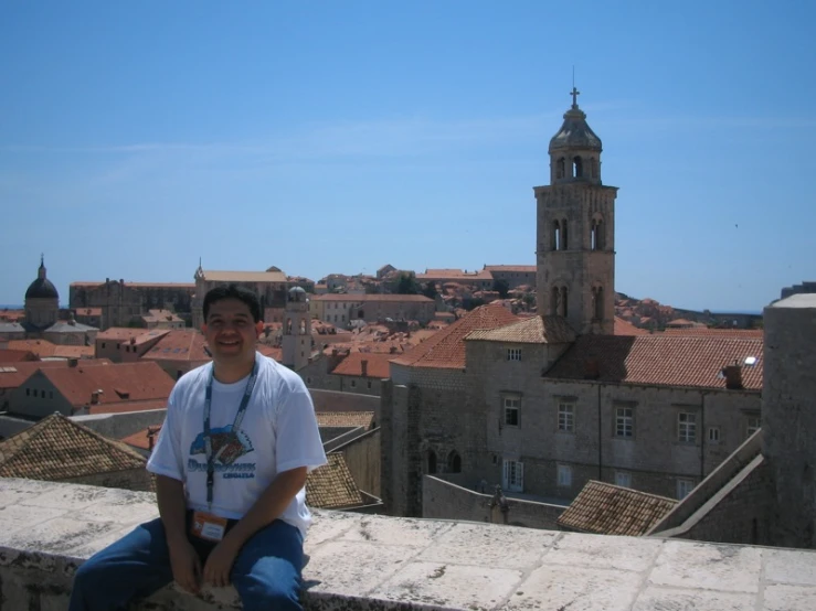 a man sitting on top of a roof next to a building