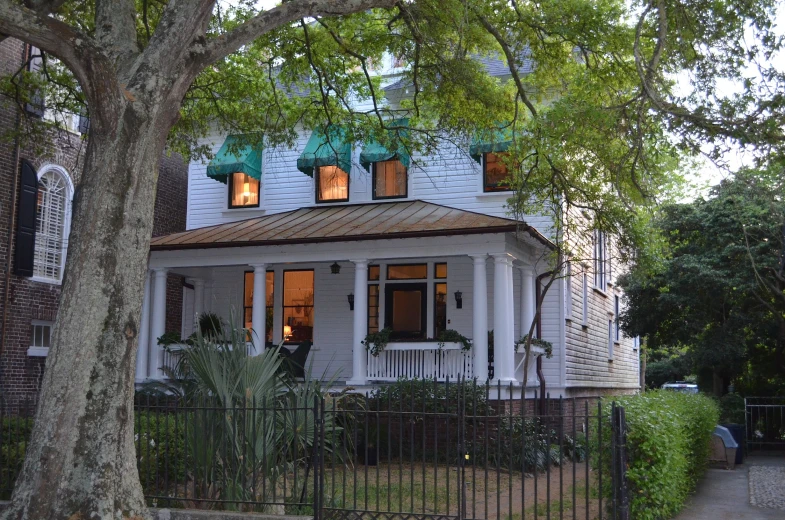 white house with three windows in a garden area