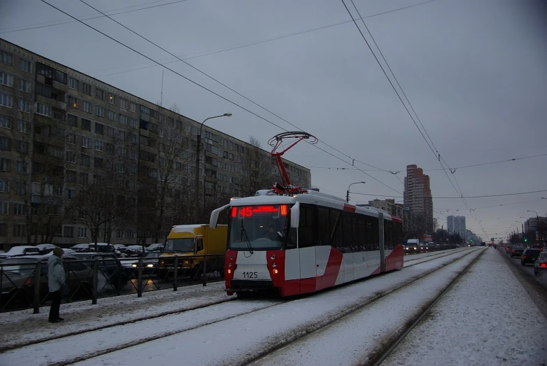 an electric train moving along the tracks through the snow