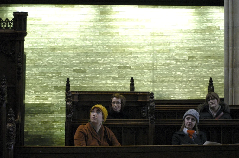 a group of people sitting on pews during a church service