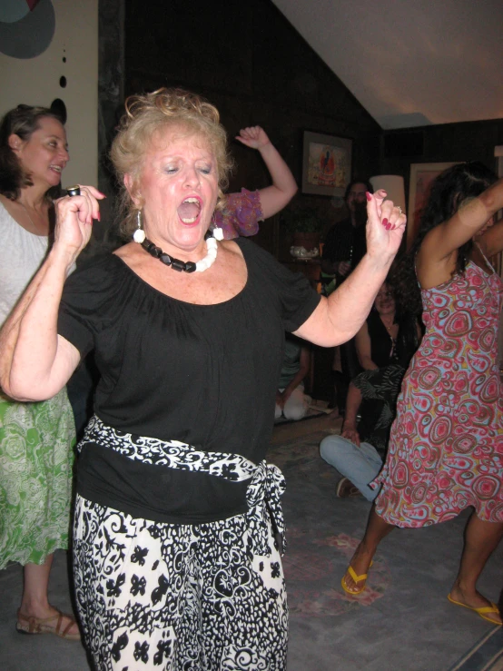 women are dancing together and they have red and white beads