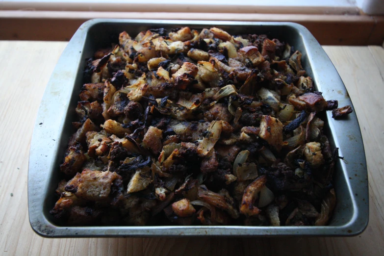 a casserole dish covered in meat and onions