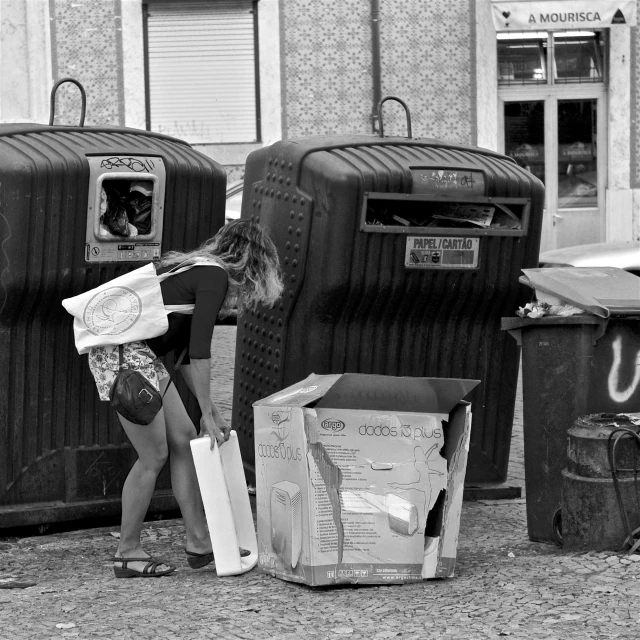 a woman carrying large boxes next to luggage