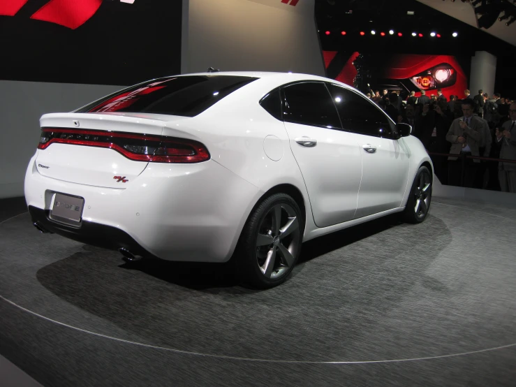 a white car is on display at a show