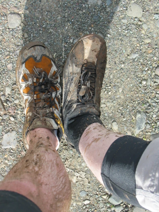 legs and feet showing muddy, dirty dirt on the ground