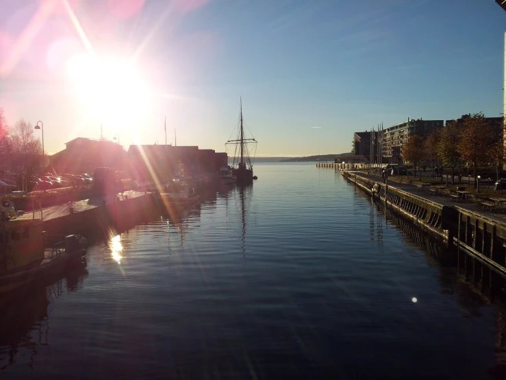 a city with boats on the river at sunset