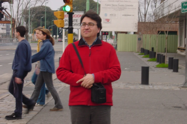 man with camera in his hand posing on street corner