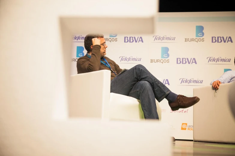 two people sitting in chairs at a conference