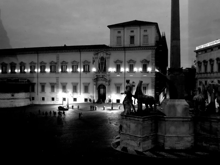 a statue is lit up next to a tall building