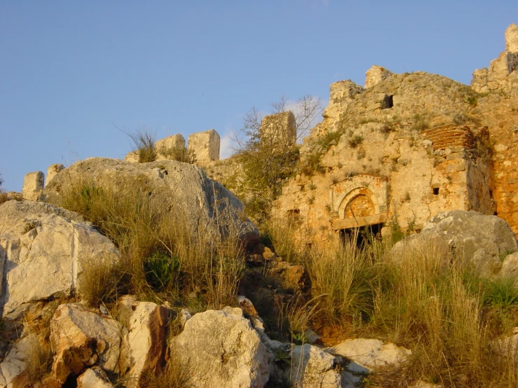 a mountain side rocky hillside with some very old and rusted stone structures