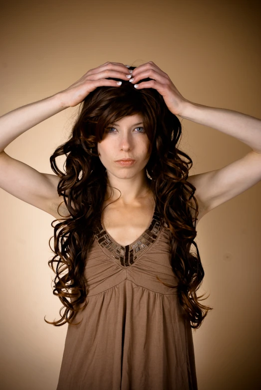 a woman wearing a brown top with long hair