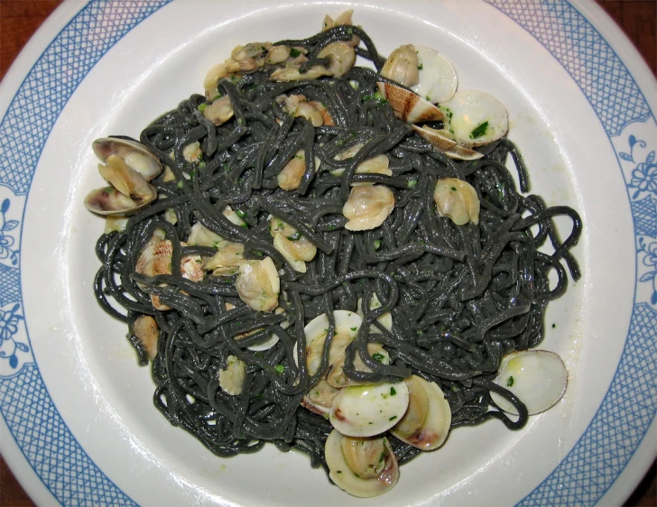a bowl of pasta with clams and black noodles