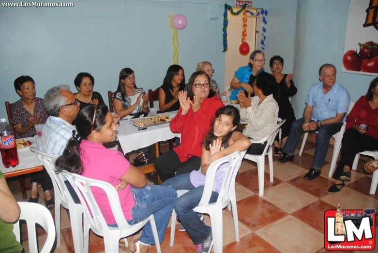 a group of people in a room with chairs around them