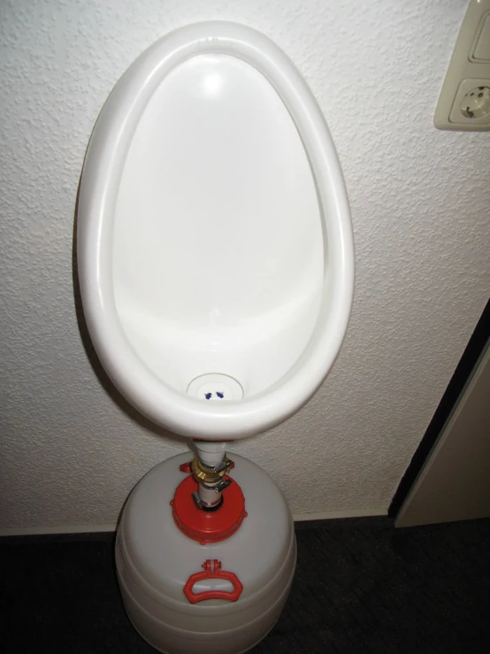 a urinal sitting in the corner of a restroom