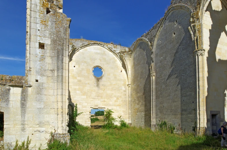 a stone building with an arched doorway in front of it